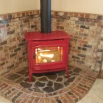 red wood burning fireplace in brick-lined corner