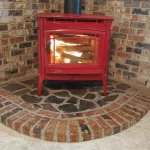 red wood burning fireplace in brick-lined corner close up