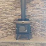 wood burning stove in brick corner on platform close up
