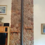 Gas powered fireplace in corner with rock background