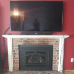 red background and tv on mantle of gas powered fireplace
