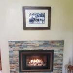 gas powered fireplace with a picture above the mantle
