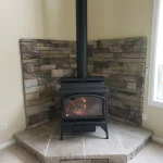 wood burning stove in corner lined with brick