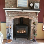 gas powered fireplace with fire-pokers next to mantle