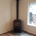 wood burning stove in corner of room