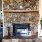 river rock backdrop to wood burning fireplace