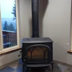 wood burning fireplace in corner near window