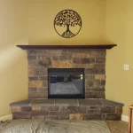 gas powered fireplace with tree artwork above